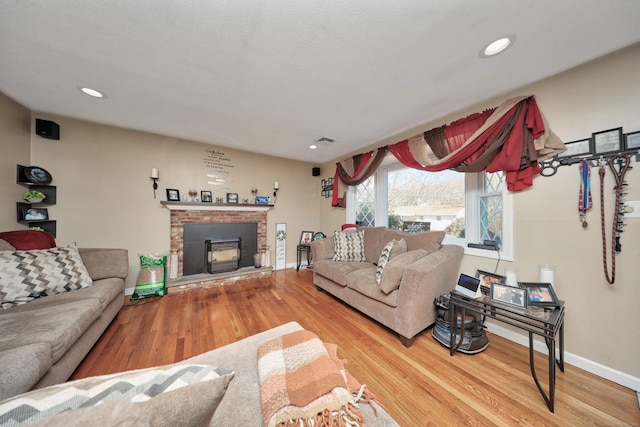 living room with recessed lighting, visible vents, baseboards, and wood finished floors