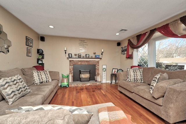 living area featuring recessed lighting, visible vents, baseboards, and wood finished floors