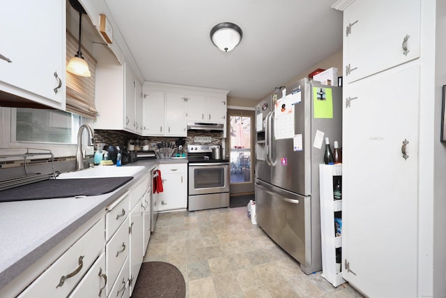 kitchen with white cabinets, stainless steel appliances, light countertops, under cabinet range hood, and a sink