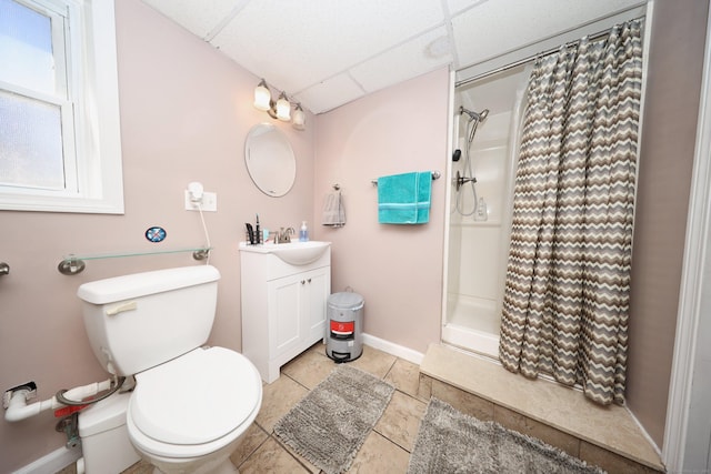 bathroom with baseboards, a drop ceiling, toilet, a shower with curtain, and vanity