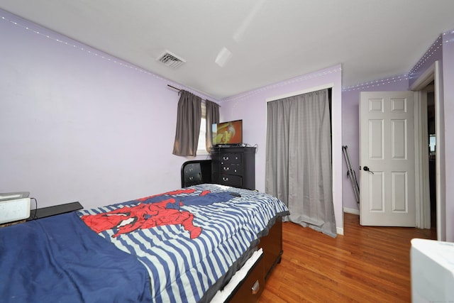 bedroom featuring visible vents and wood finished floors