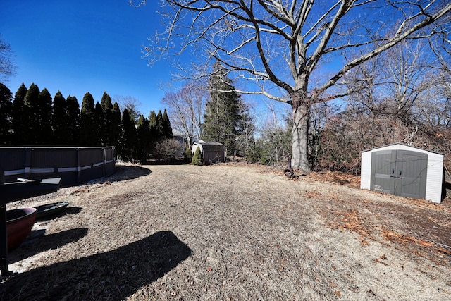 view of yard featuring an outbuilding, an outdoor pool, and a shed