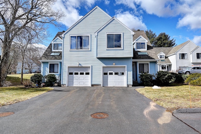 view of front of home with driveway, roof with shingles, a garage, and a front yard