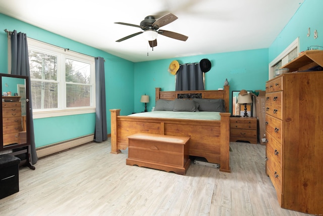 bedroom featuring a baseboard heating unit, wood finished floors, and a ceiling fan