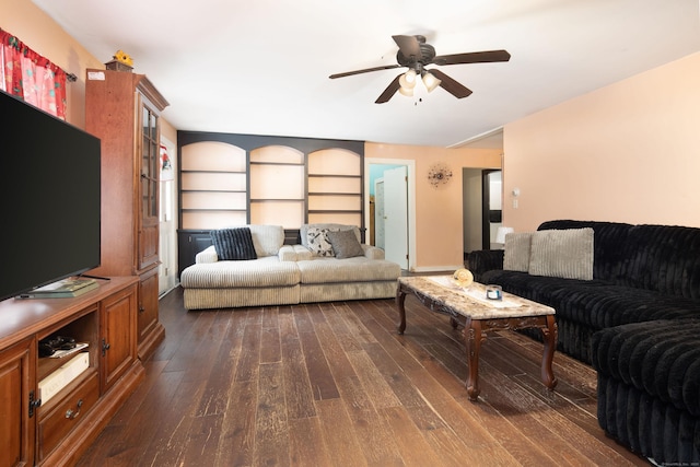 living area with a ceiling fan and dark wood-type flooring