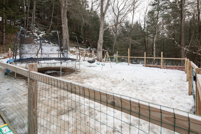 yard layered in snow with a trampoline and playground community