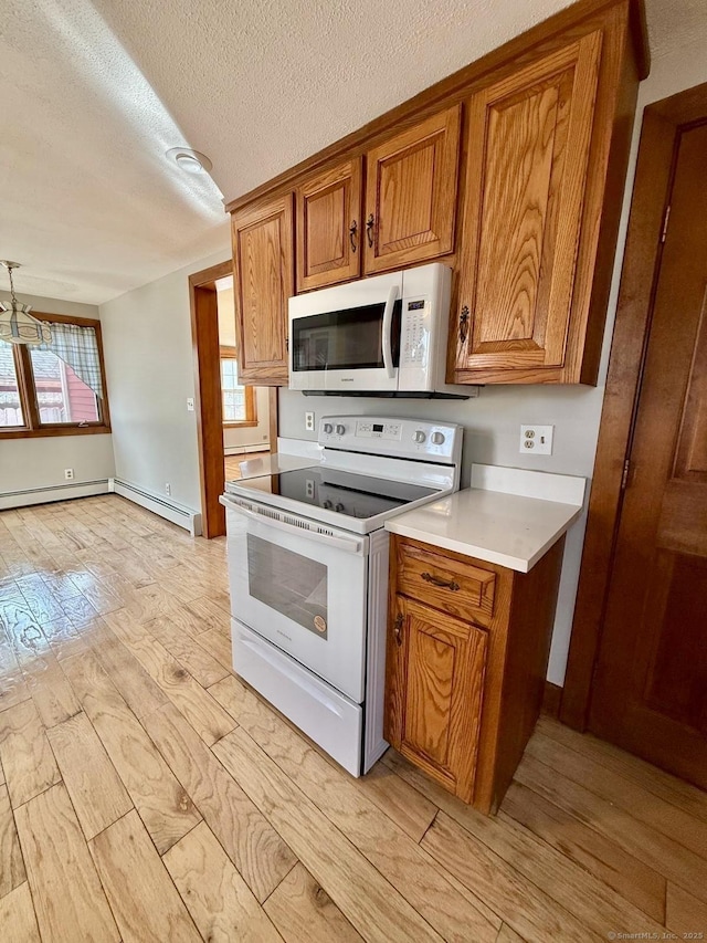 kitchen featuring light countertops, white appliances, brown cabinets, and a textured ceiling