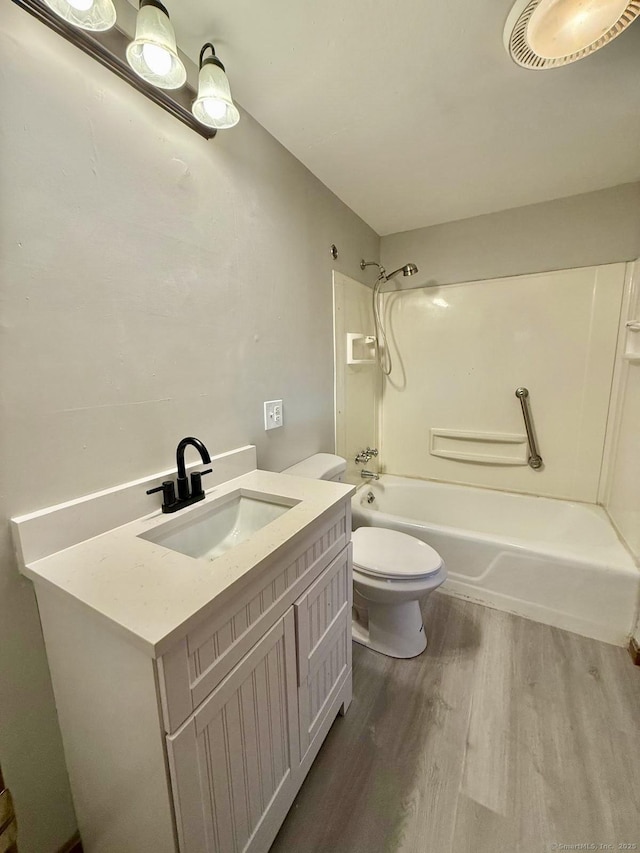 bathroom with shower / washtub combination, visible vents, toilet, vanity, and wood finished floors