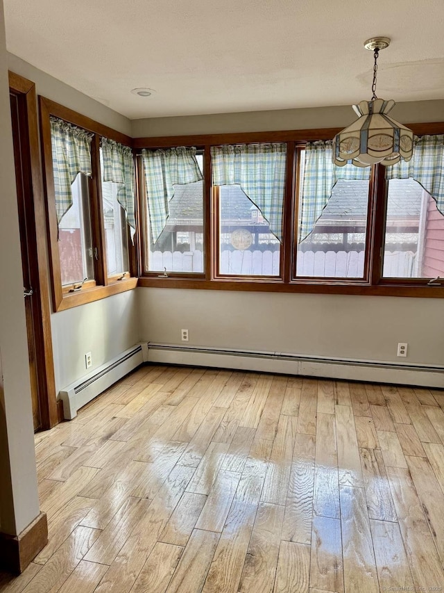 interior space with light wood-style floors and baseboard heating