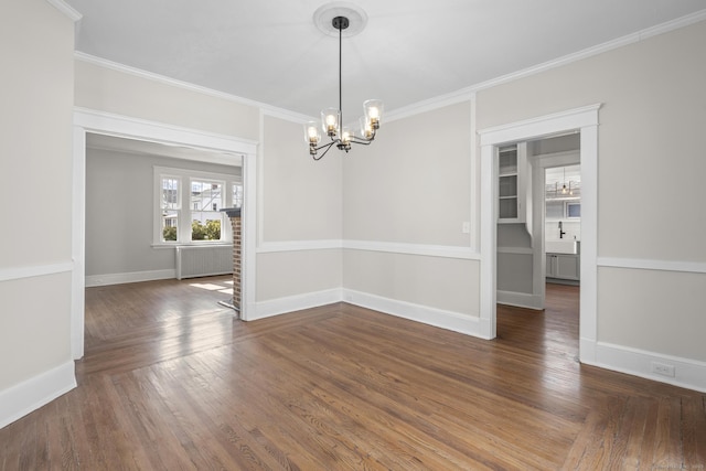 unfurnished dining area featuring crown molding, a notable chandelier, and radiator