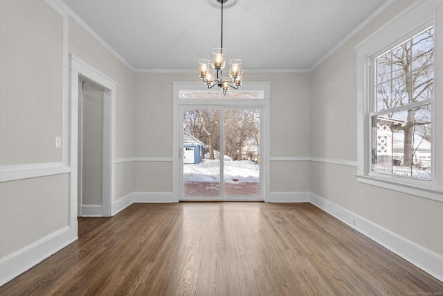 unfurnished dining area featuring an inviting chandelier, plenty of natural light, and wood finished floors