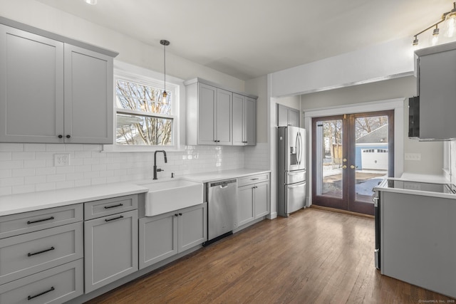 kitchen with a sink, gray cabinets, stainless steel appliances, and light countertops