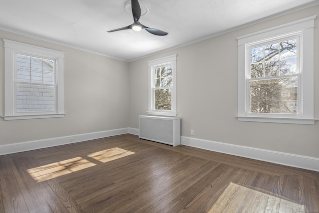 empty room with baseboards, a healthy amount of sunlight, crown molding, and radiator heating unit