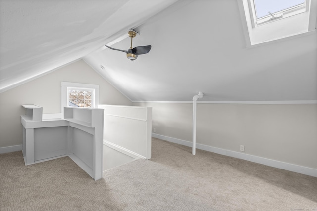 bonus room featuring lofted ceiling with skylight, light carpet, and baseboards