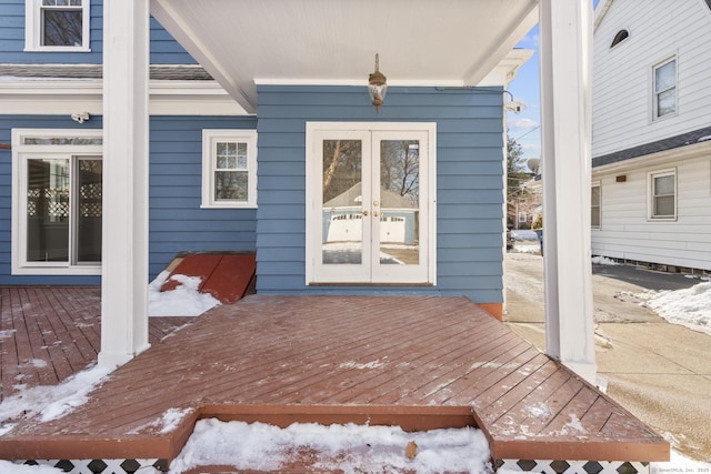 snow covered property entrance with french doors