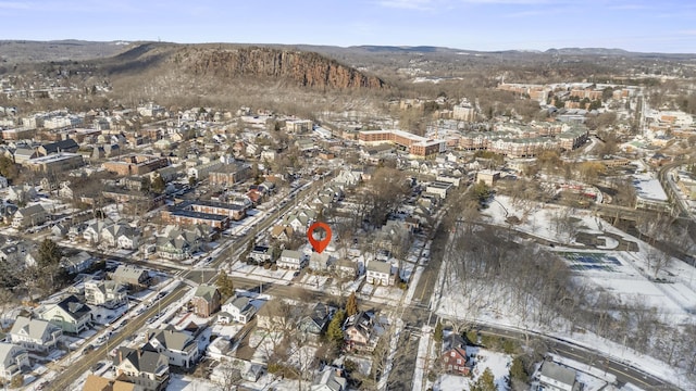 snowy aerial view featuring a residential view and a mountain view