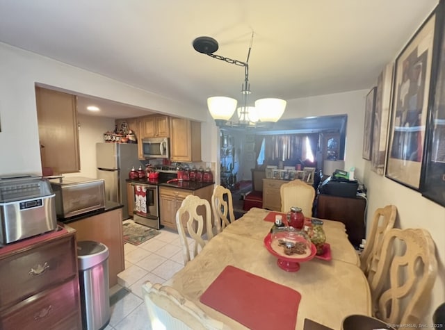 dining room featuring a notable chandelier and light tile patterned flooring