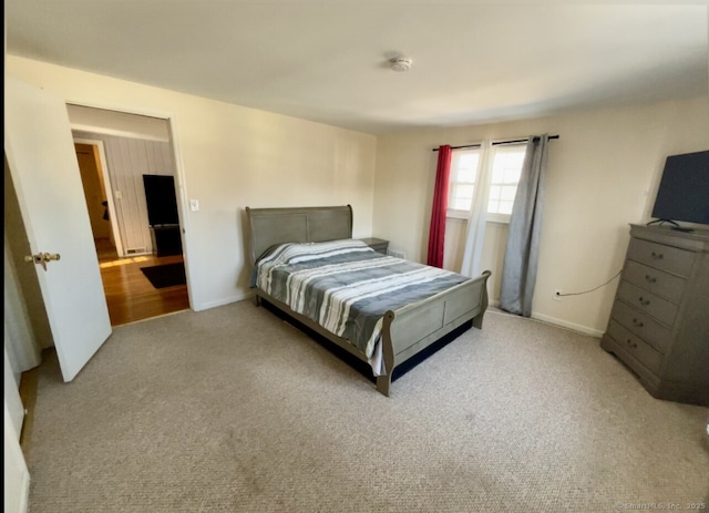 bedroom featuring baseboards and light colored carpet