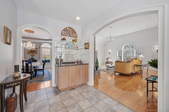 interior space featuring a chandelier, dark countertops, and arched walkways