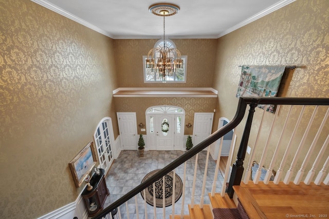 entryway with a chandelier, stairway, crown molding, and wallpapered walls