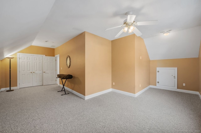 bonus room featuring lofted ceiling, ceiling fan, baseboards, and light colored carpet