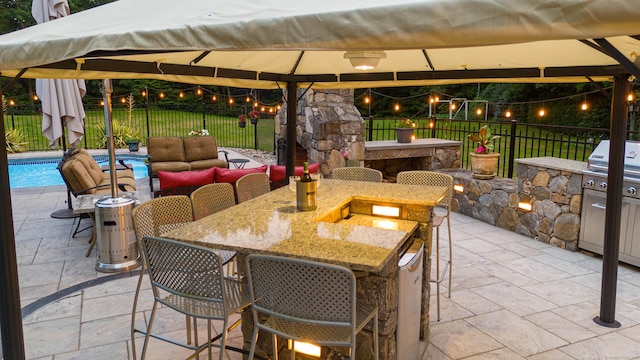 view of patio / terrace with an outdoor bar, fence, and a gazebo