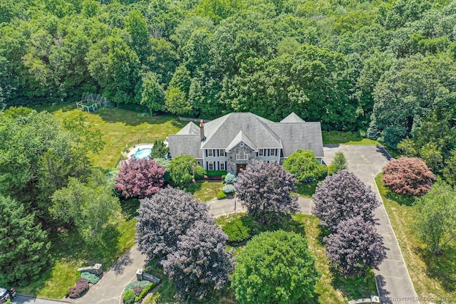 birds eye view of property featuring a view of trees