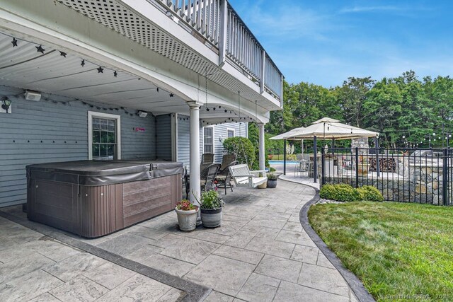 view of patio featuring a balcony, a hot tub, fence, and a gazebo