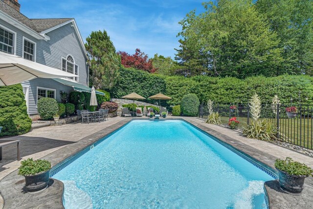 view of swimming pool with a fenced in pool, fence, and a patio