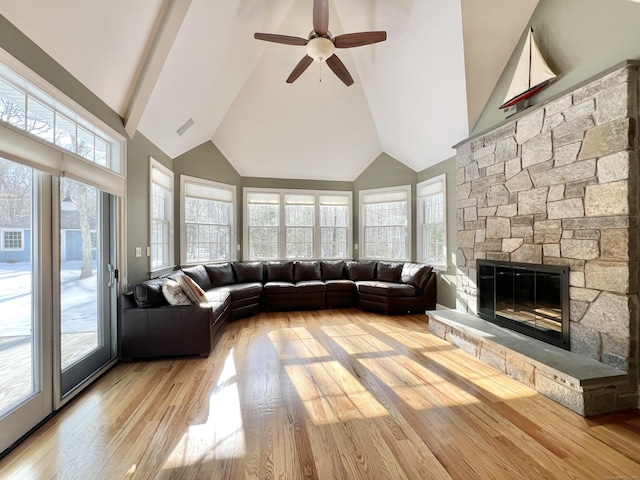 unfurnished living room with high vaulted ceiling, a fireplace, light wood-style flooring, and ceiling fan