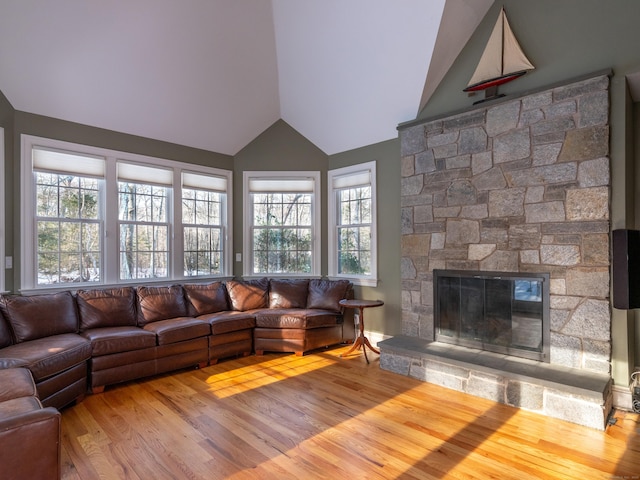 unfurnished living room featuring lofted ceiling, a fireplace, and wood finished floors