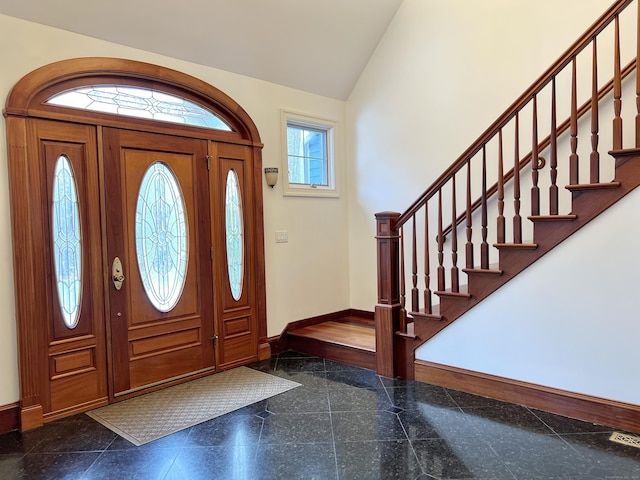 foyer with vaulted ceiling, granite finish floor, stairway, and baseboards