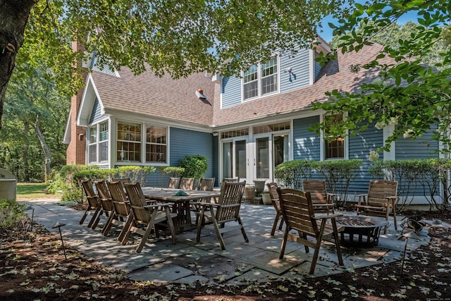 back of house with french doors, a patio area, and roof with shingles