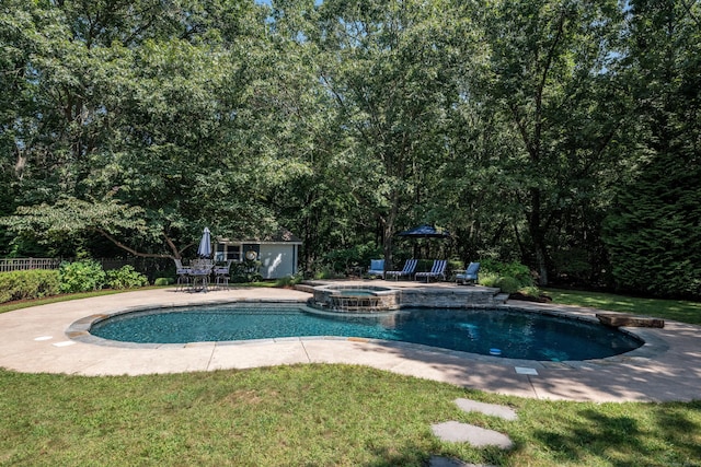 view of pool featuring a patio area, a pool with connected hot tub, a yard, and an outbuilding