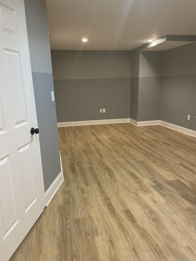 finished basement featuring baseboards and wood finished floors