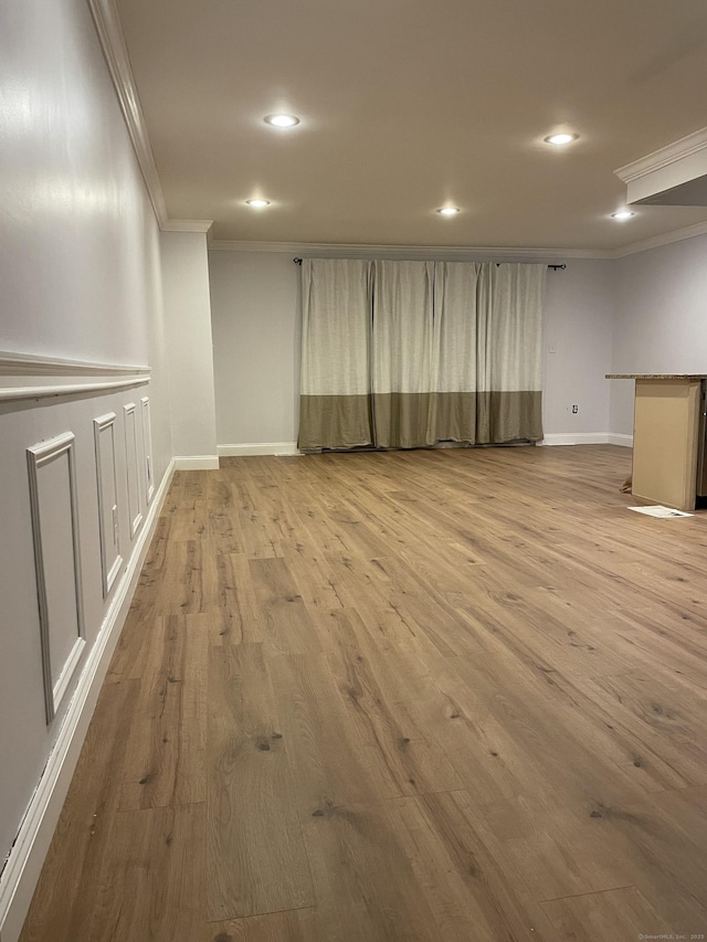 empty room with recessed lighting, crown molding, baseboards, and wood finished floors