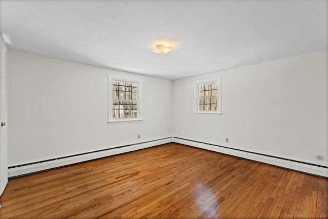 spare room featuring wood-type flooring and a baseboard radiator