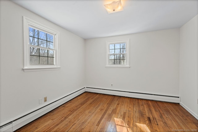 spare room featuring a baseboard radiator and hardwood / wood-style flooring