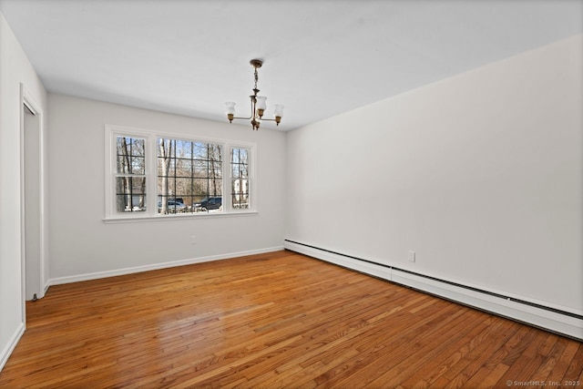 empty room with a baseboard radiator, light wood-style flooring, baseboards, and an inviting chandelier