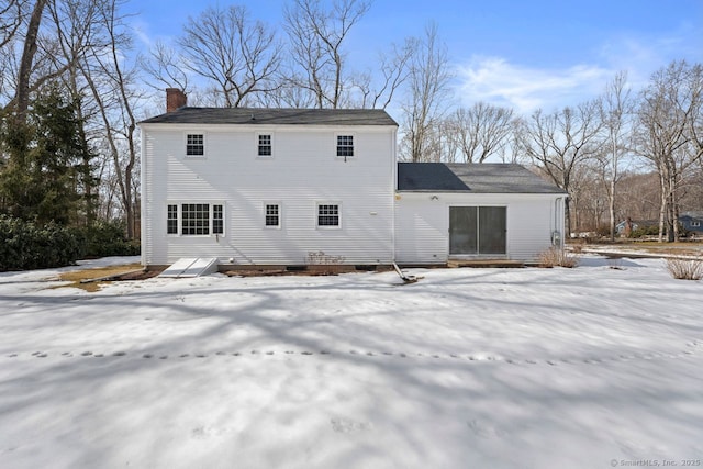 snow covered property featuring a chimney