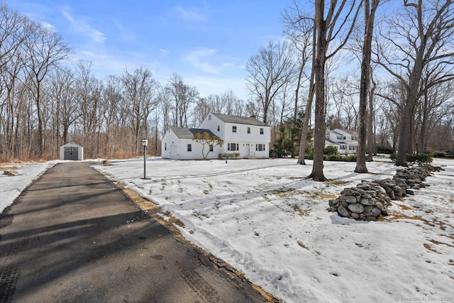 view of front of home with a storage shed and an outbuilding