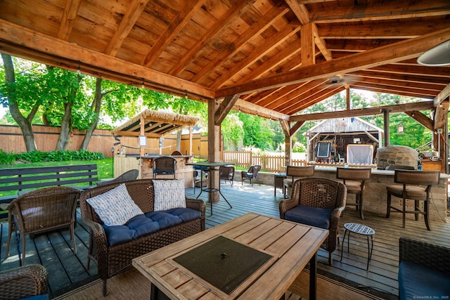 view of patio featuring outdoor dry bar, a deck, a gazebo, an outdoor living space, and outdoor dining space