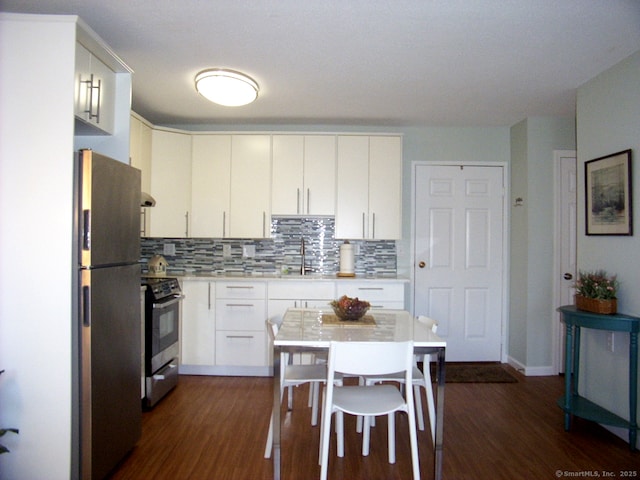 kitchen featuring dark wood-style flooring, a sink, light countertops, appliances with stainless steel finishes, and decorative backsplash