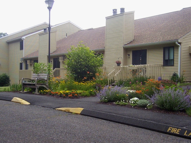 view of front of property featuring a shingled roof and a chimney