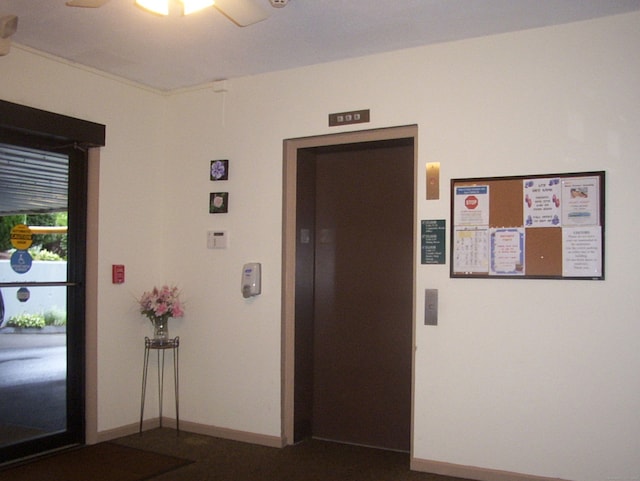 corridor featuring elevator and baseboards