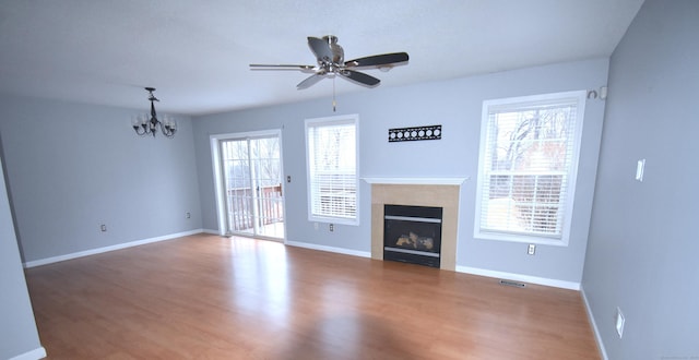 unfurnished living room featuring visible vents, a fireplace, baseboards, and wood finished floors