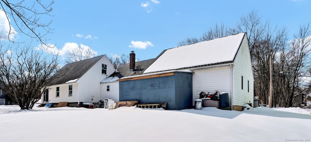 snow covered property featuring a chimney