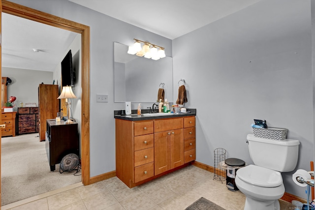 bathroom with toilet, tile patterned floors, vanity, and baseboards