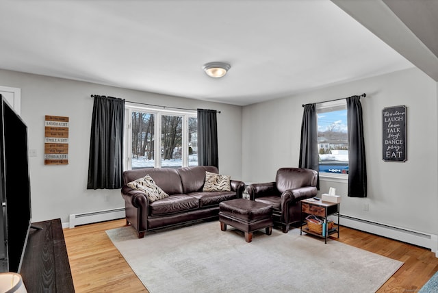 living area with baseboards, baseboard heating, and wood finished floors