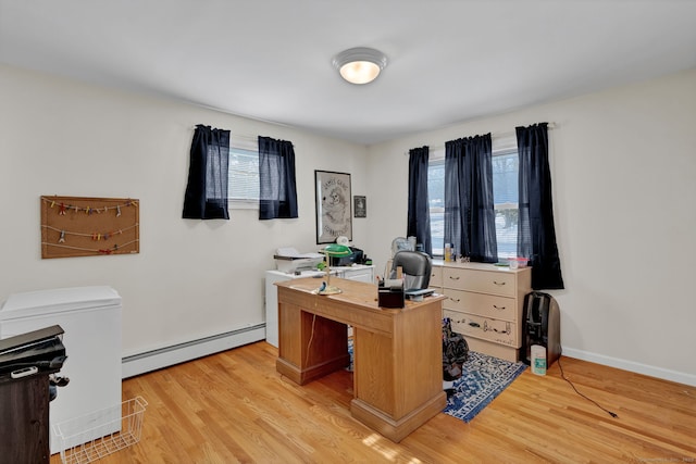 office featuring a baseboard heating unit, baseboards, and light wood finished floors